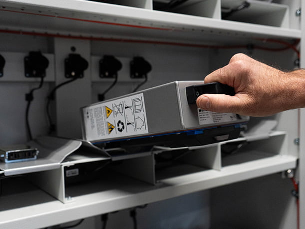 Elektrische pompwagen en palletwagen. Accu veilig opladen in de Batteryguard accukast. Klik eenvoudig de accu in het oplaadstation.